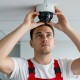 Junge Person montiert eine Überwachungskamera