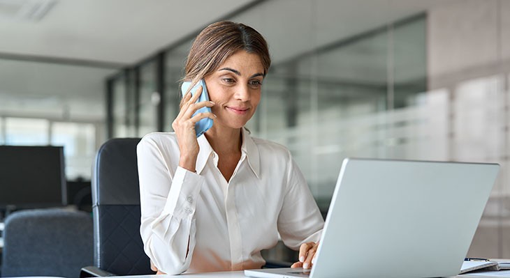 © insta_photos - Adobe Stock Frau telefoniert und schaut auf Laptop
