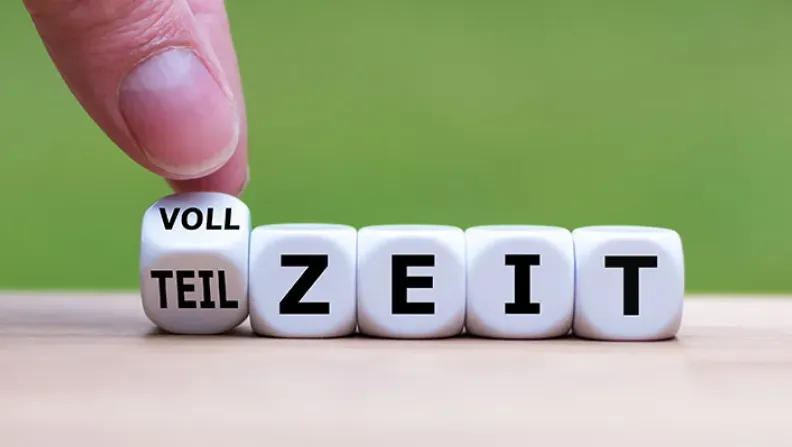 © Frank H. - Adobe Stock Hand dreht einen Würfel und ändert das Wort "Teilzeit" in "Vollzeit".